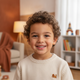 Headshot portrait of a happy young boy, smiling and looking directly at the camera, with a soft, warm background.